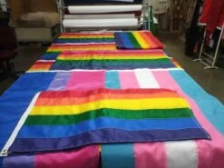 Rainbow Flag -flag sale rainbow flags laying across production table close up